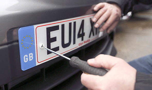 a man fixing number plates on his car